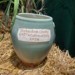 Handmade clay crock with "Shenandaoh County 4H/FFA Gallon of Milk 2024 written on side.